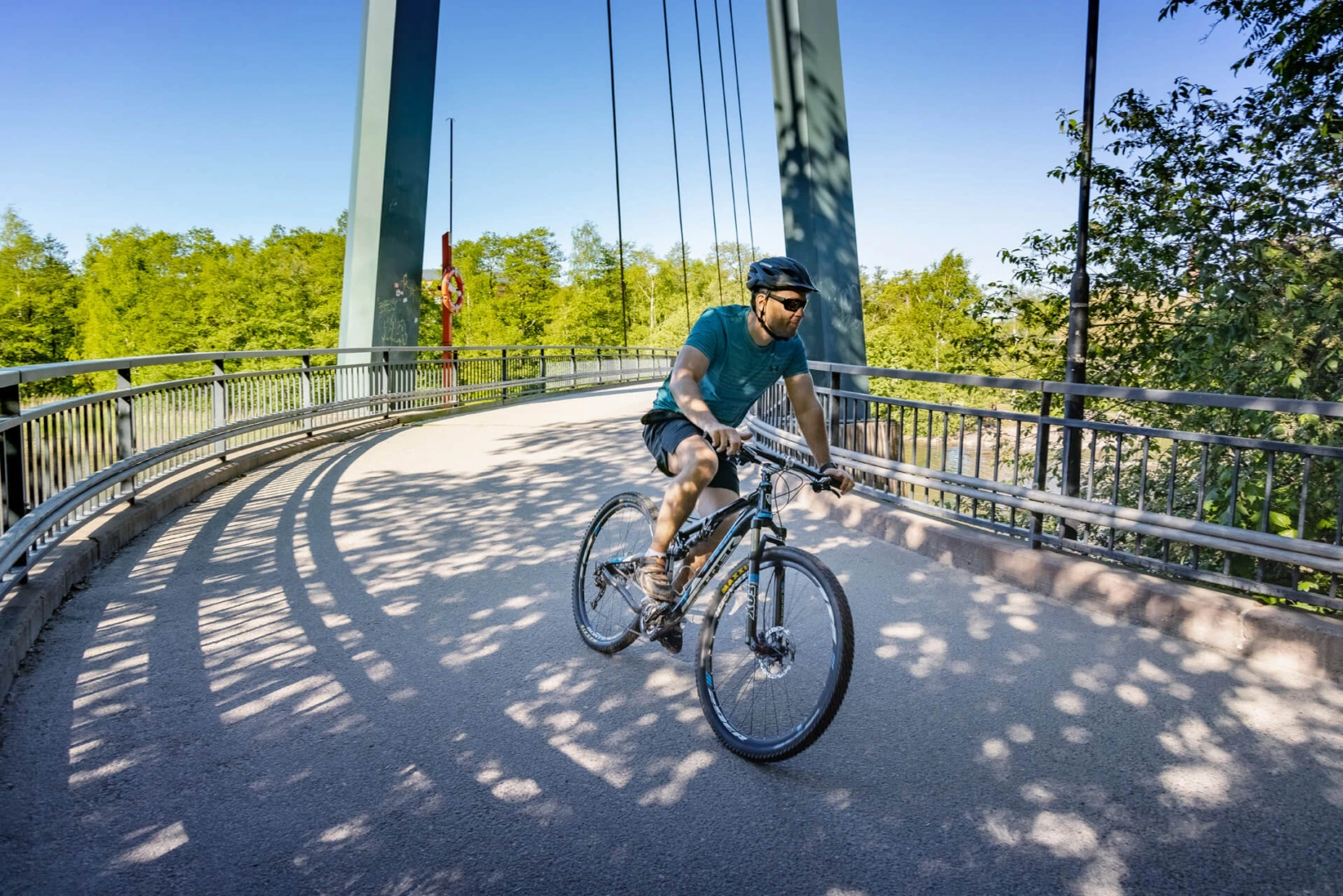 Mies ajaa maastopyörällä sillalla