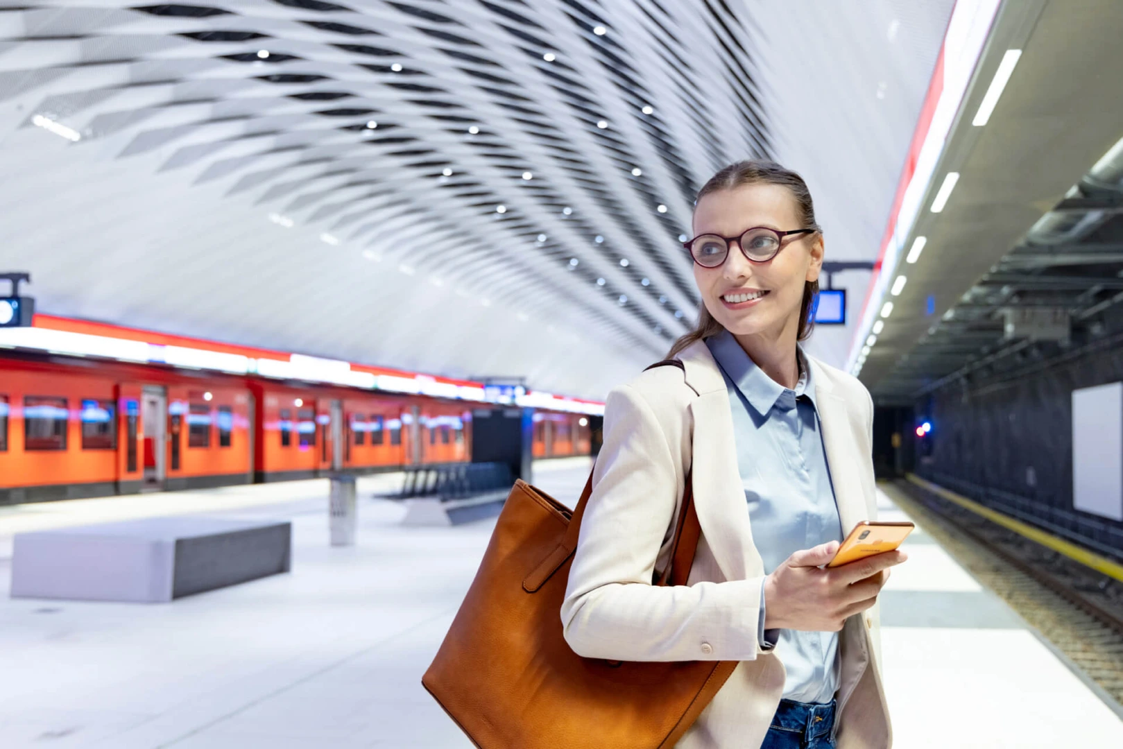 Nainen metroasemalla puhelin kädessä